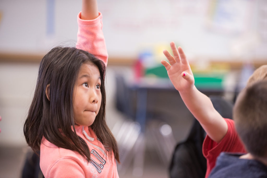 Girl raing arm in gym class. Photograph by Jeff Woodward.