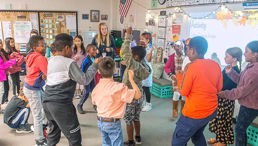 A class of students having fun in a Responsive Classroom Morning Meeting activity